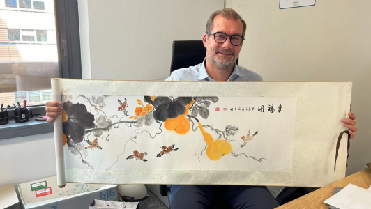 图为PVCP太阳季集团CEO Stéphane Laugery与赠送的“千岛湖·梓桐新农人艺术品”合影